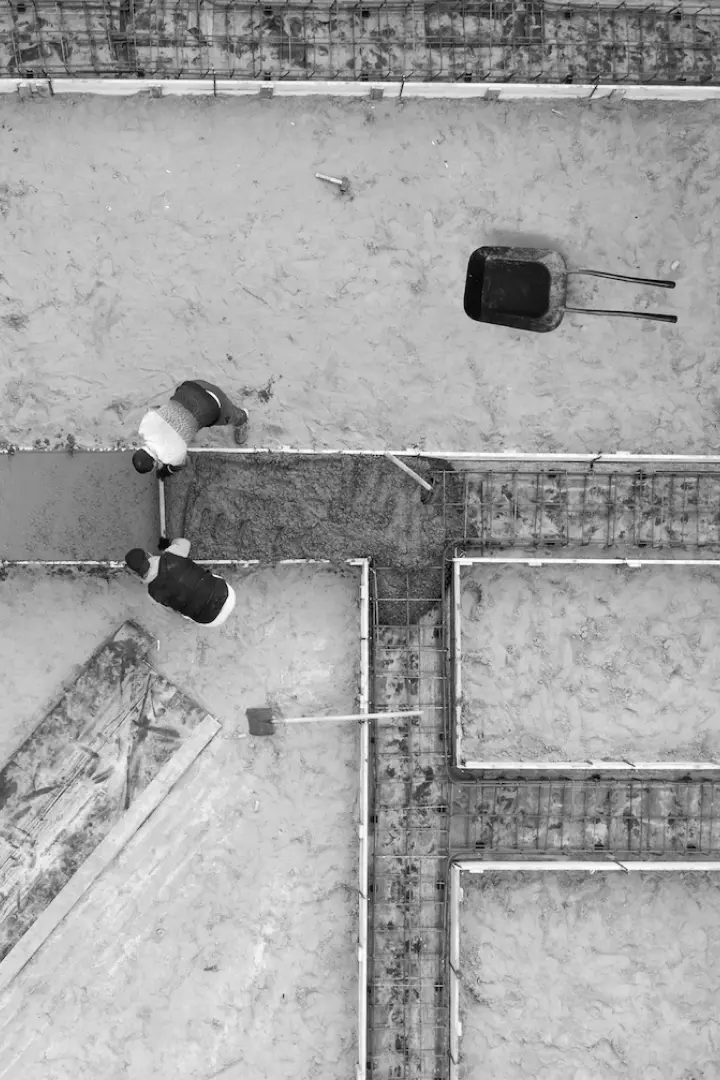 Wet cement being poured into a foundation form.